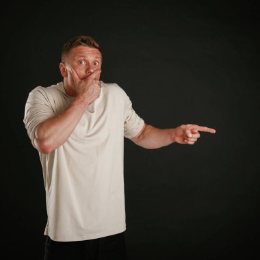 Yanında korkunç bir şey var, işaret ediyor. Adam stüdyoda arka plana karşı..