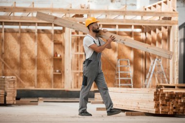 Yürüyorum, kalas tutuyorum. Ahşap depoda sanayi işçisi..