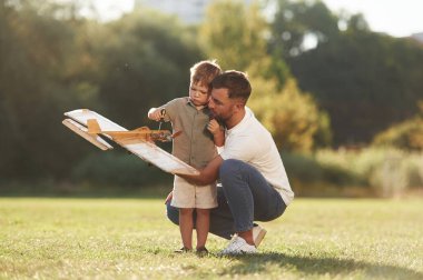 Tornavidayla tamir etmeye çalışıyorum. Baba ve oğul oyuncak uçakla sahadalar..