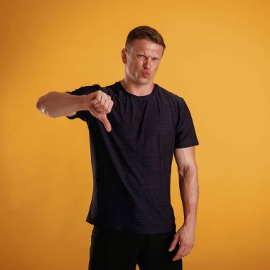 Tatmin olmamış, hoşnutsuzluk gösteriyor. Adam stüdyoda arka plana karşı..