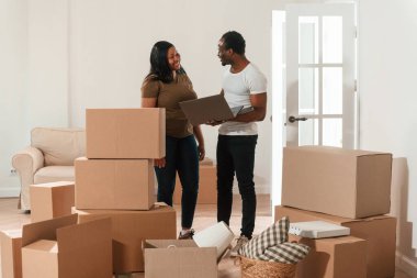 Dizüstü bilgisayarla. Afrikalı Amerikalı çift yeni eve taşınıyor..