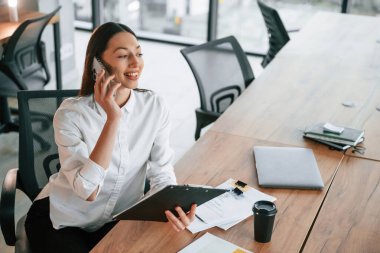 Telefonla konuşarak. İş kadını ofisin içinde..