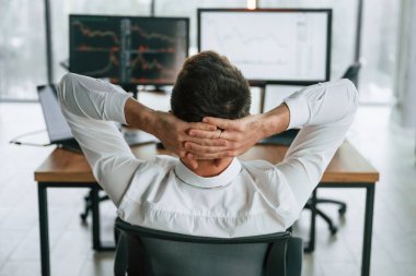 Dikiz aynası. İşadamı bilgisayar başında oturuyor ve ofiste çalışıyor..