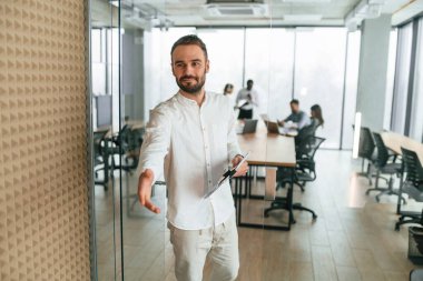 Evrakları olan bir adam var. Ofis çalışanlarından oluşan ekip içeride bir arada..