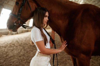 Sakin sahne, ayakta. Güzel genç bir kadın atıyla içeride..