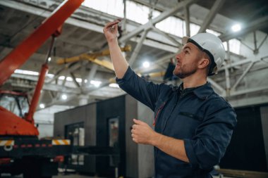 Süreci kontrol etmek, el hareketleri, iletişim. Erkek işçi, modern depo veya imalat şirketinde çalışıyor..