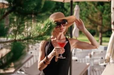 Bir bardak kokteyl. Güzel genç bayan tatil köyünde..