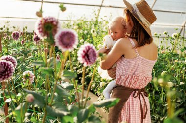 Güzel çiçeklere bakıyorum. Anne ve kızı serada..