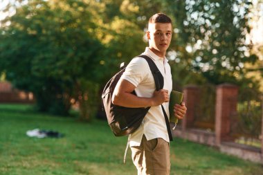 Sırt çantasıyla. Genç erkek öğrenci dışarıda..