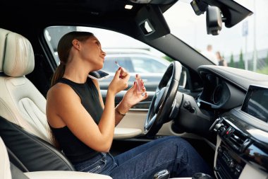 Yan görüş, telefonla konuşma. Kadın arabada oturuyor..