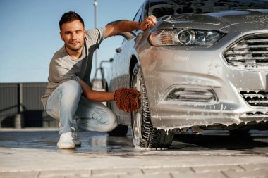 Oturup otomobili yıkıyorum. Adam dışarıda arabasıyla bekliyor..