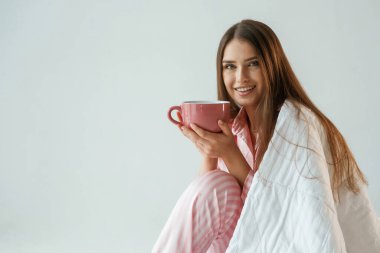 Büyük bir bardak içki. Günaydın, uyanıyorum. Genç ve güzel bir bayan stüdyoda arka plana karşı..