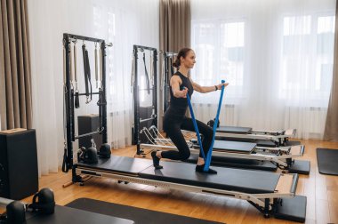 Spor seansı. Genç bayan antrenman malzemeleriyle spor salonunda..