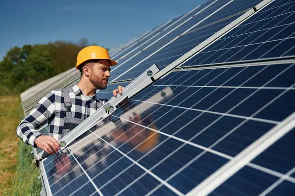 Dengeleyiciyi kullanarak. Gündüz vakti fotovoltaik güneş panelleri olan bir mühendis..