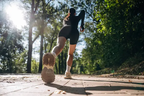 Düşük görüş, koşu, koşu. Genç, sıska kadın dışarıda siyah spor kıyafetleri giyiyor..