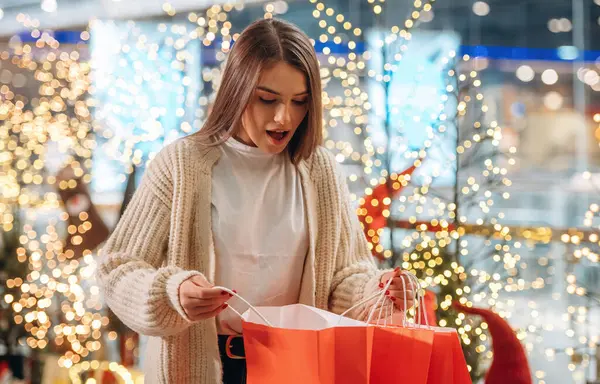 Hediye beni şaşırttı. Yeni yıl alışverişi ve hediyeleri. Kadın Noel ağacının yanında..