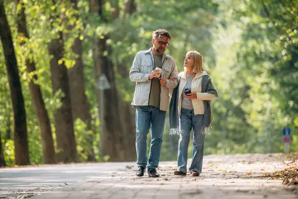 Ellerinde kahve fincanları, etrafta dolanıyorlar. Doğada üst düzey çiftler birlikte..