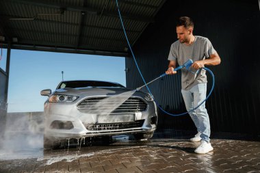 Durup otomobili yıkıyorum. Adam dışarıda arabasıyla bekliyor..