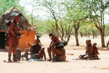 Namibya, Afrika - 14 Haziran 2021: Etnik insanlar, kadınlar eski tarz evlerinin yakınında bir araya geldiler.
