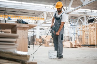 Büyük matkap. Ahşap depoda sanayi işçisi..