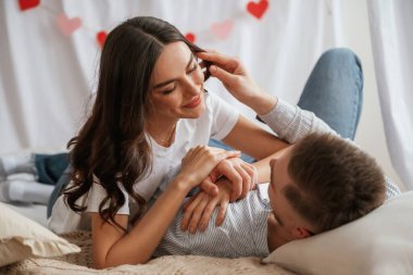 Sevgililer Günü için kırmızı süslemeli arka plan. Genç çift evde birlikteler..