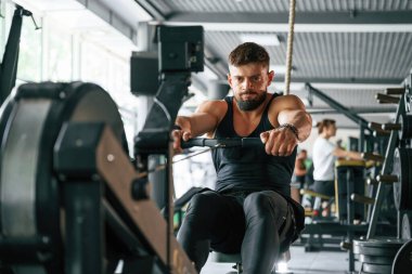 Dayanıklılık egzersizi. Güçlü kaslı adam spor salonunda çalışıyor..