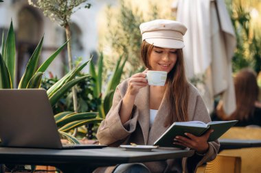 Bilgiyi okuyorum. Güzel, genç bir bayan restoranın dışında, masanın yanında..