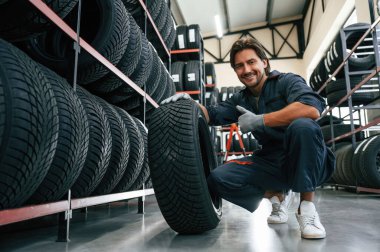 Olumlu yüz ifadesi. Lastik tamir servisinde adam var..