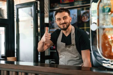 Başparmak yukarı. Adam lezzetli sokak yemekleri sunuyor..