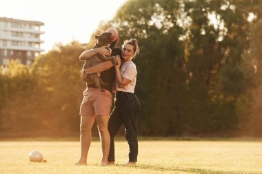 Sevimli bir çift, hayvanları ellerinde tutuyorlar. Erkek ve kadın sahada köpekle birlikteler..