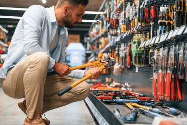 Bahçe makasıyla. Adam hırdavatçıda..