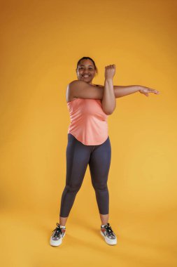 Eller için alıştırmaları ısıt. Afrikalı Amerikalı kadın sarı arka planda stüdyoda..