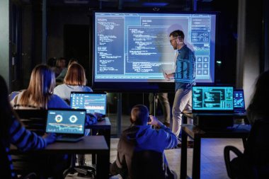 Projeden bahsediyorum. Erkek işletme eğitmeni projektöre karşı, insanlara öğretiyor..