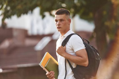 Günlük kıyafetlerle. Genç erkek öğrenci dışarıda..