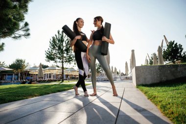 Yürüyüş yapmak güzel bir gün ışığı. İki fitness kadını açık havada birlikte, spor anlayışı..