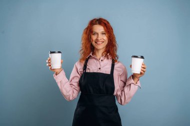 Garsonun elinde iki içki. Kadın stüdyoda arka planda..