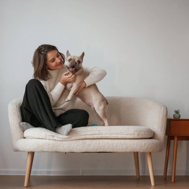 Birlikte oturuyoruz. Genç kadın köpeğiyle evde..