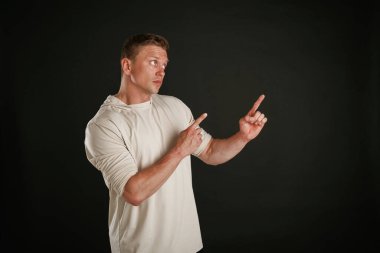 Yeni ürün, kopyalama alanında gösteriliyor. Adam stüdyoda arka plana karşı..