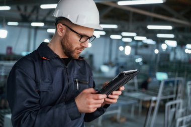 Tabletteki verileri okuyorum. Fabrika işçisi kasketli bir şekilde içeride..