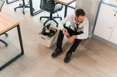 Yerde oturduğum için kendimi kötü hissediyorum. İşsiz adam kovulduktan sonra kişisel eşyalarıyla birlikte..