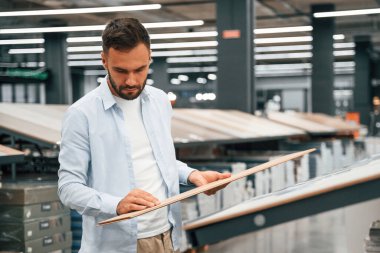 Farklı renkte parke. Adam hırdavatçıda..