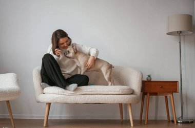 Genç kadın köpeğiyle evde..