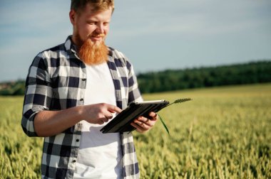 Dijital tabletle kalite kontrol süreci. Beyaz gömlekli adam tarlada..