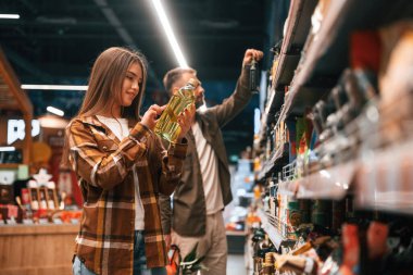 Ellerinde yağ var. Genç çift süpermarkette beraberler..