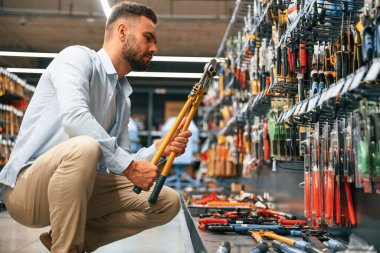 Bahçe makasıyla. Adam hırdavatçıda..