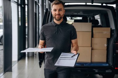 Kalem ve not defteri ellerinde. Teslimatçı ya da yükleyici