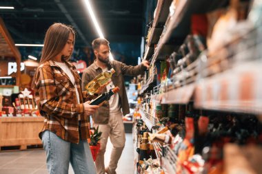 Ellerinde yağ var. Genç çift süpermarkette beraberler..