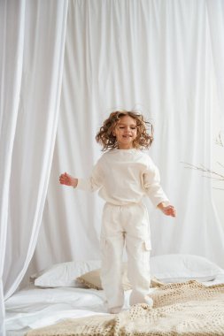 Yatakta zıplarken eğleniyorum. Şirin küçük kız evde..