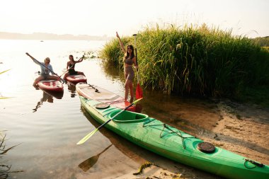 Aktif hafta sonu, denizde. Kadın arkadaşlar gölde birlikte yemek yiyorlar..