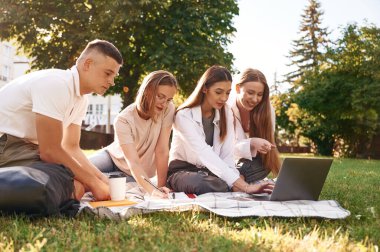 Hazırlık, oturma ve öğrenme. Bir grup öğrenci birlikte dışarı çıktılar..